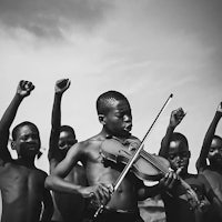 a black and white photo of a group of boys playing a violin